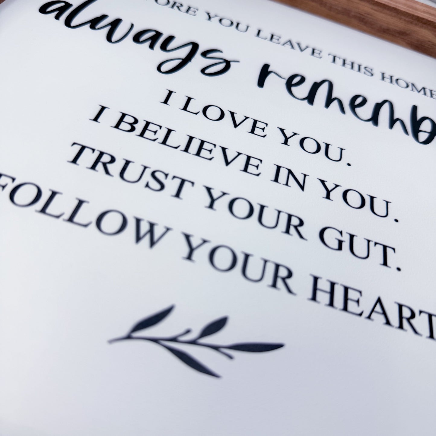 Motivational quote on a white background with a wooden frame.