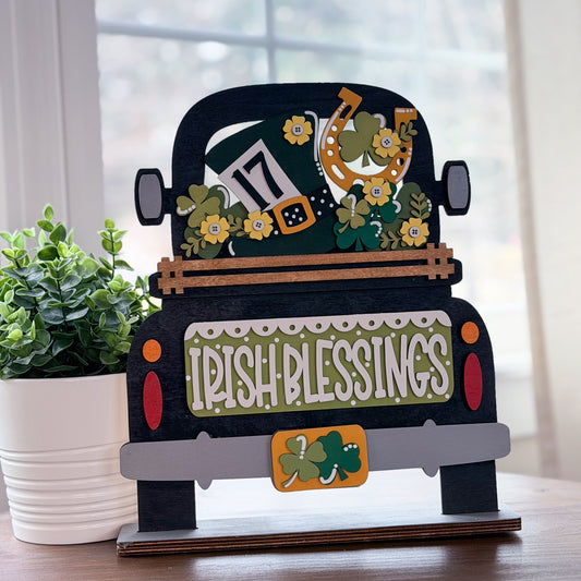 Decorative sign shaped like a truck with 'Irish Blessings' text, surrounded by plants.