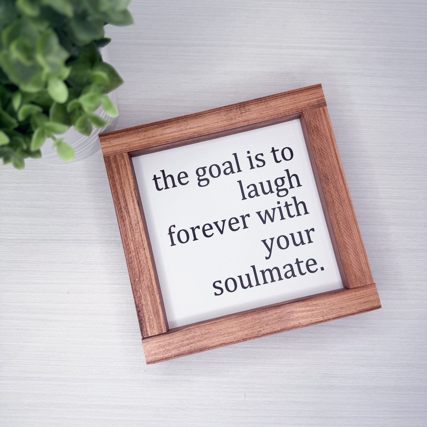 Wooden frame with motivational quote on a light background