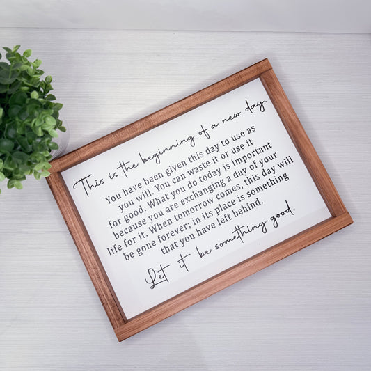 Framed motivational quote on a white background with a wooden frame
