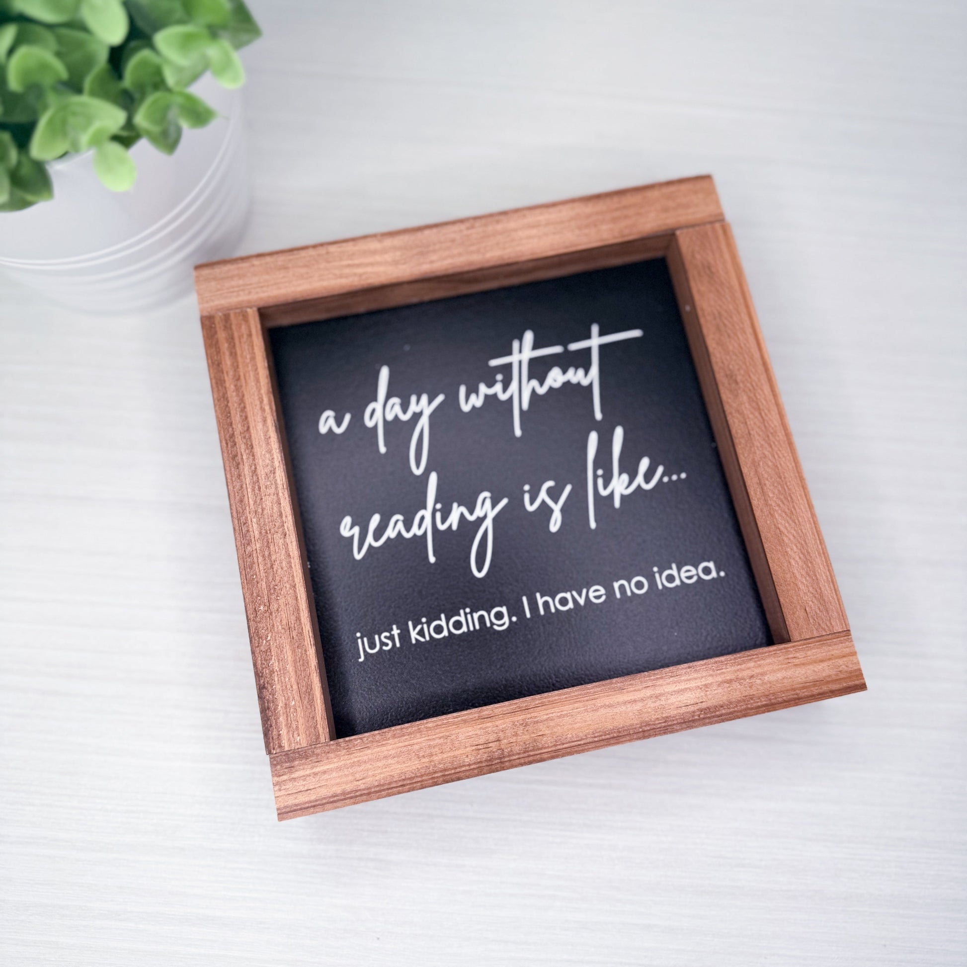 Small framed sign with humorous quote on a light background