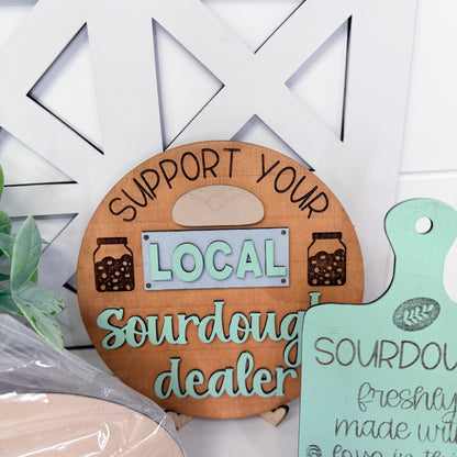 Wooden sign with 'Support your local sourdough dealer' text on a white background