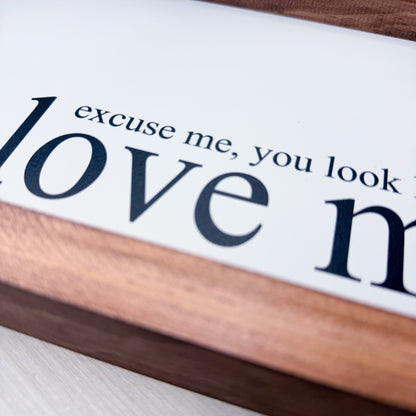 Wooden block with text 'love me, you look' on a white background