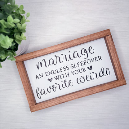 Wooden-framed sign with humorous quote on a white background