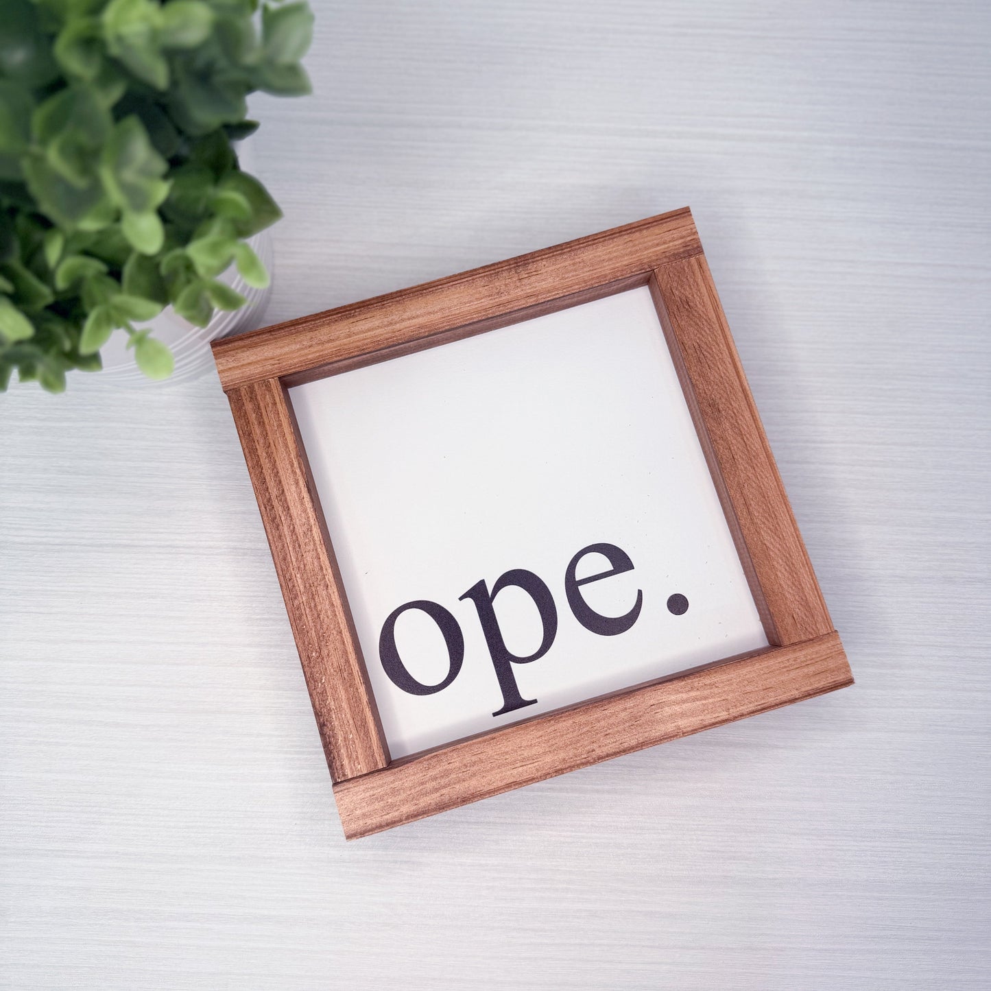 Wooden frame with 'ope.' text on a light background