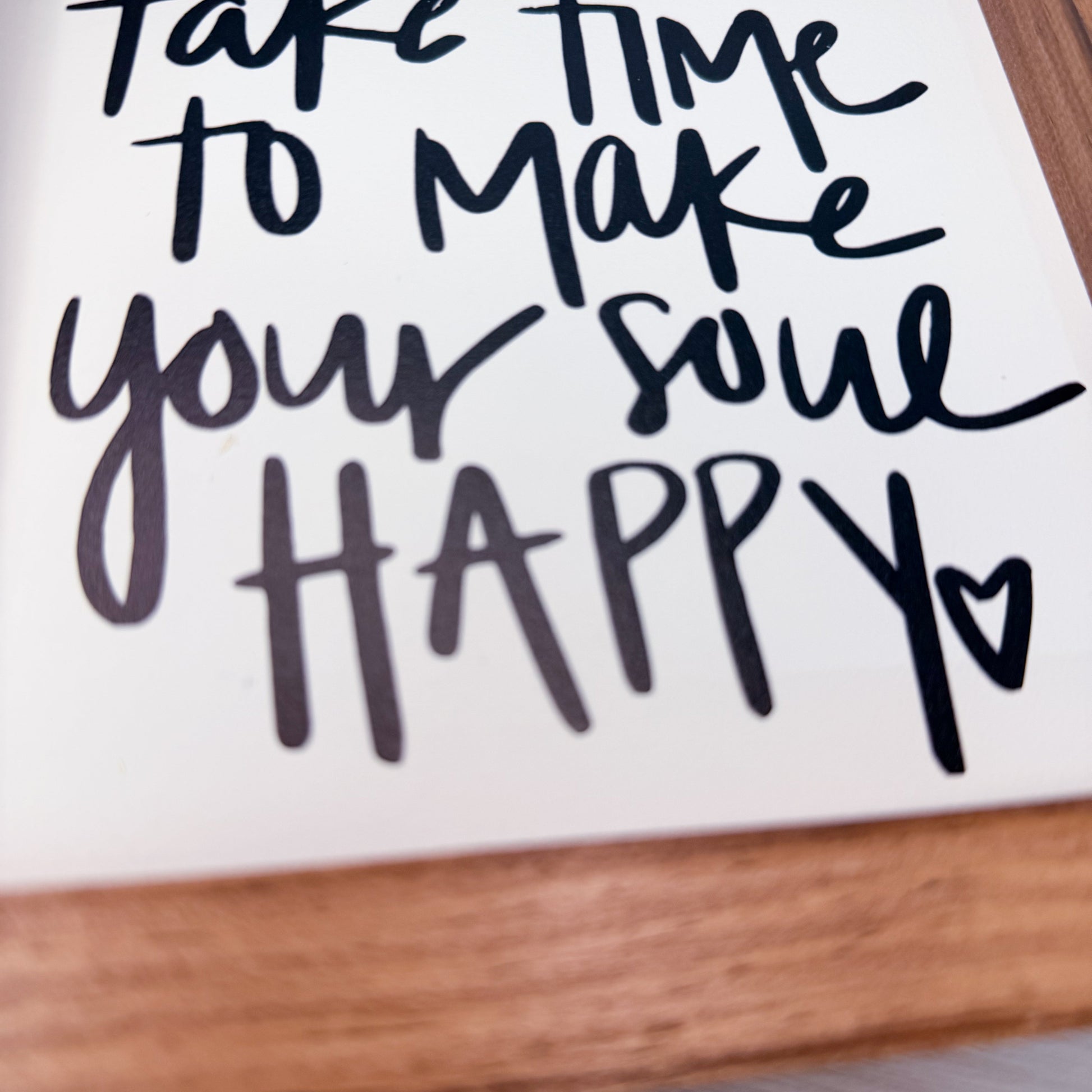 Motivational quote 'Take time to make your soul happy' on a white background with a wooden frame.