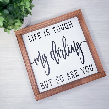 Wooden-framed sign with motivational quote on a light background
