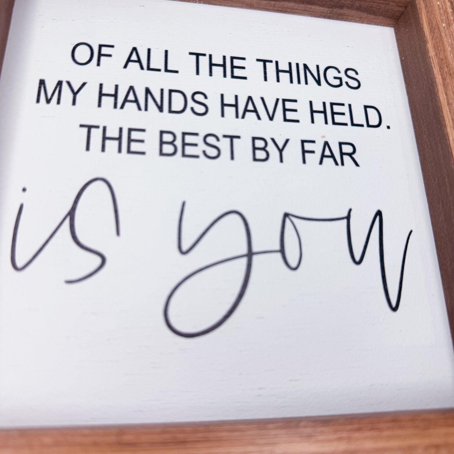 Framed quote card with romantic message on a wooden surface