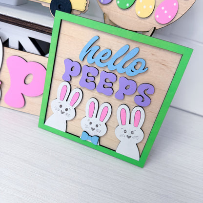 Wooden Easter sign with 'hello PEEPS' and bunny cutouts on a white background