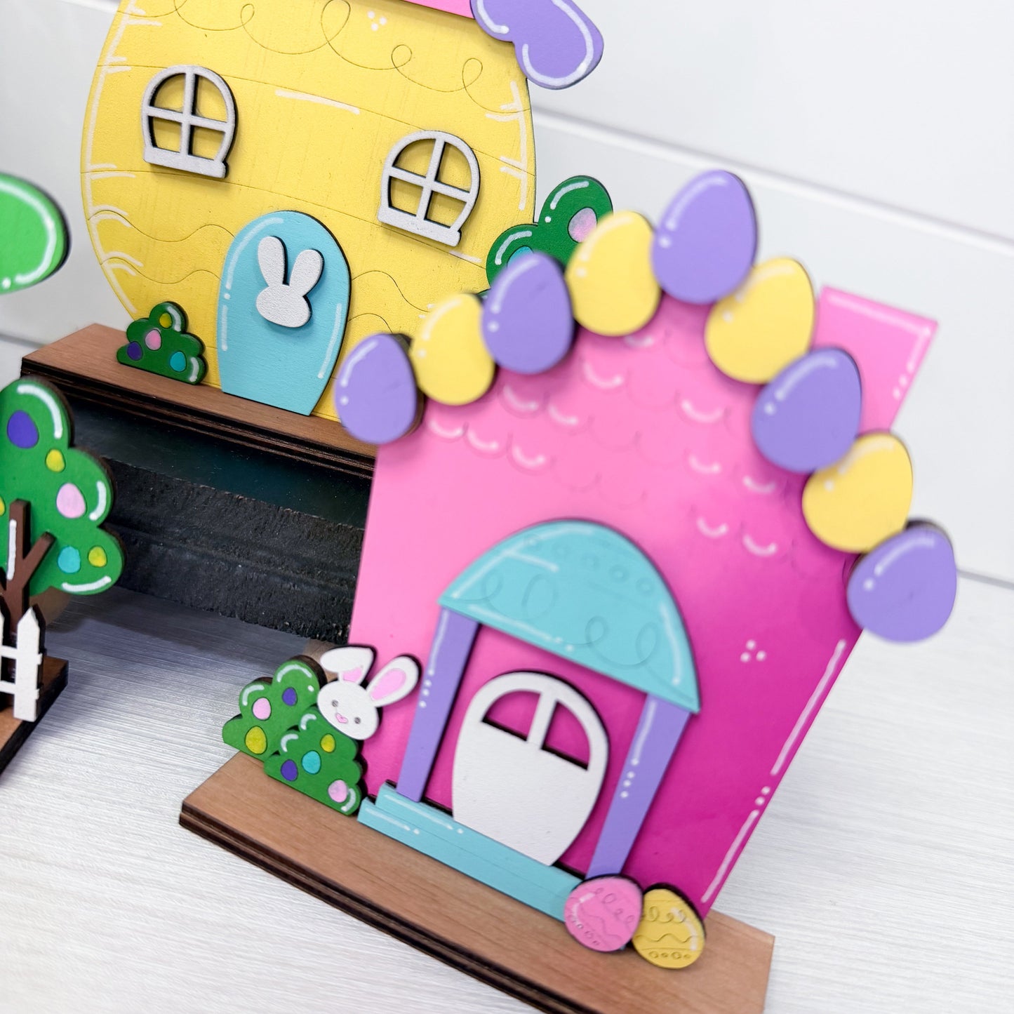Colorful wood house models with decorative elements on a white background