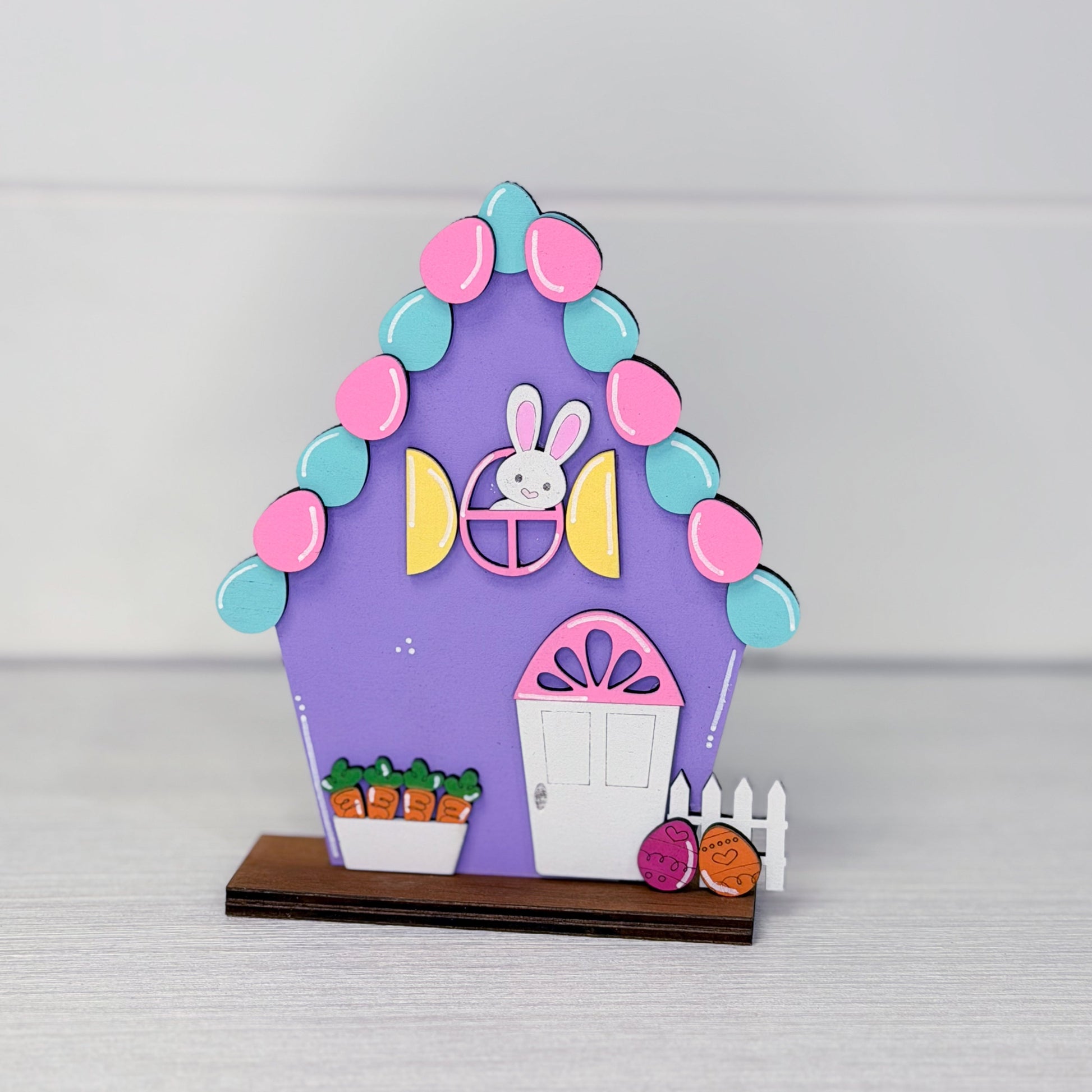Colorful Easter-themed house decoration with a rabbit face on a gray background