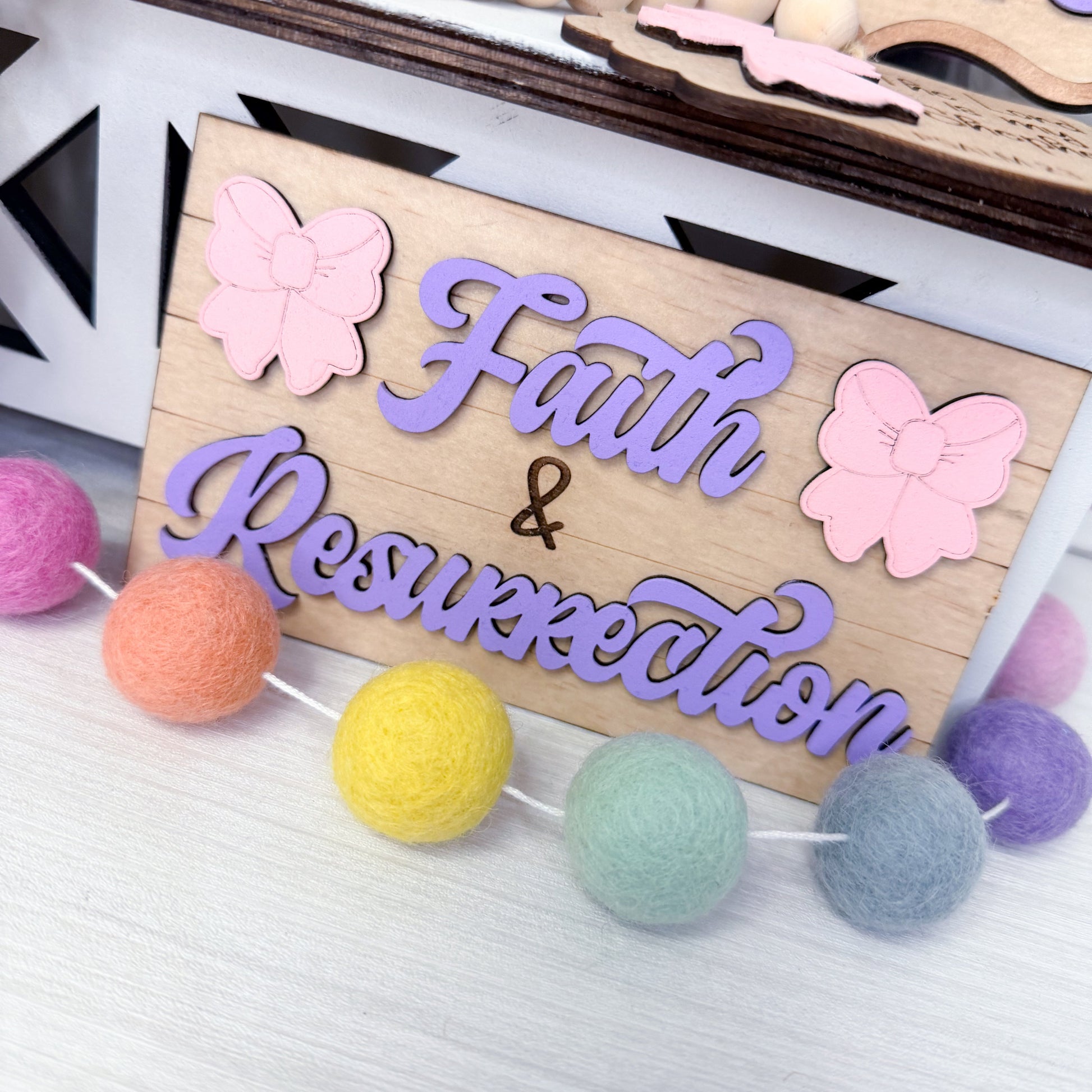 Wooden sign with 'Faith & Resurrection' and butterfly decorations on a white background
