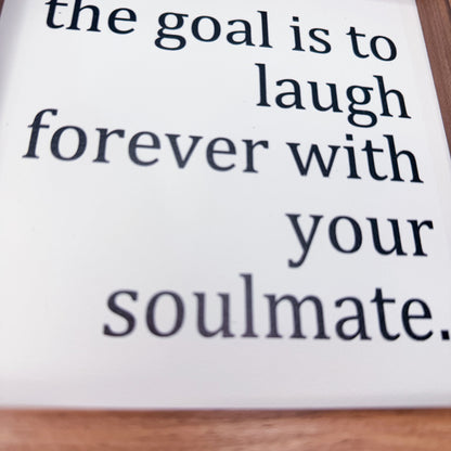 White sign with black text on a wooden surface