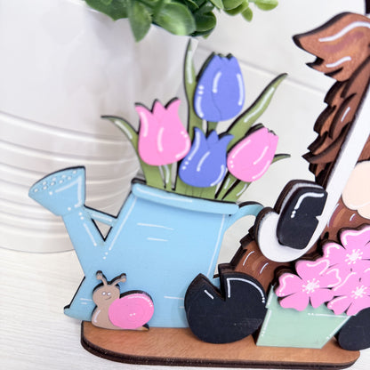 Decorative set with a watering can, flowers, and a gnome on a white background