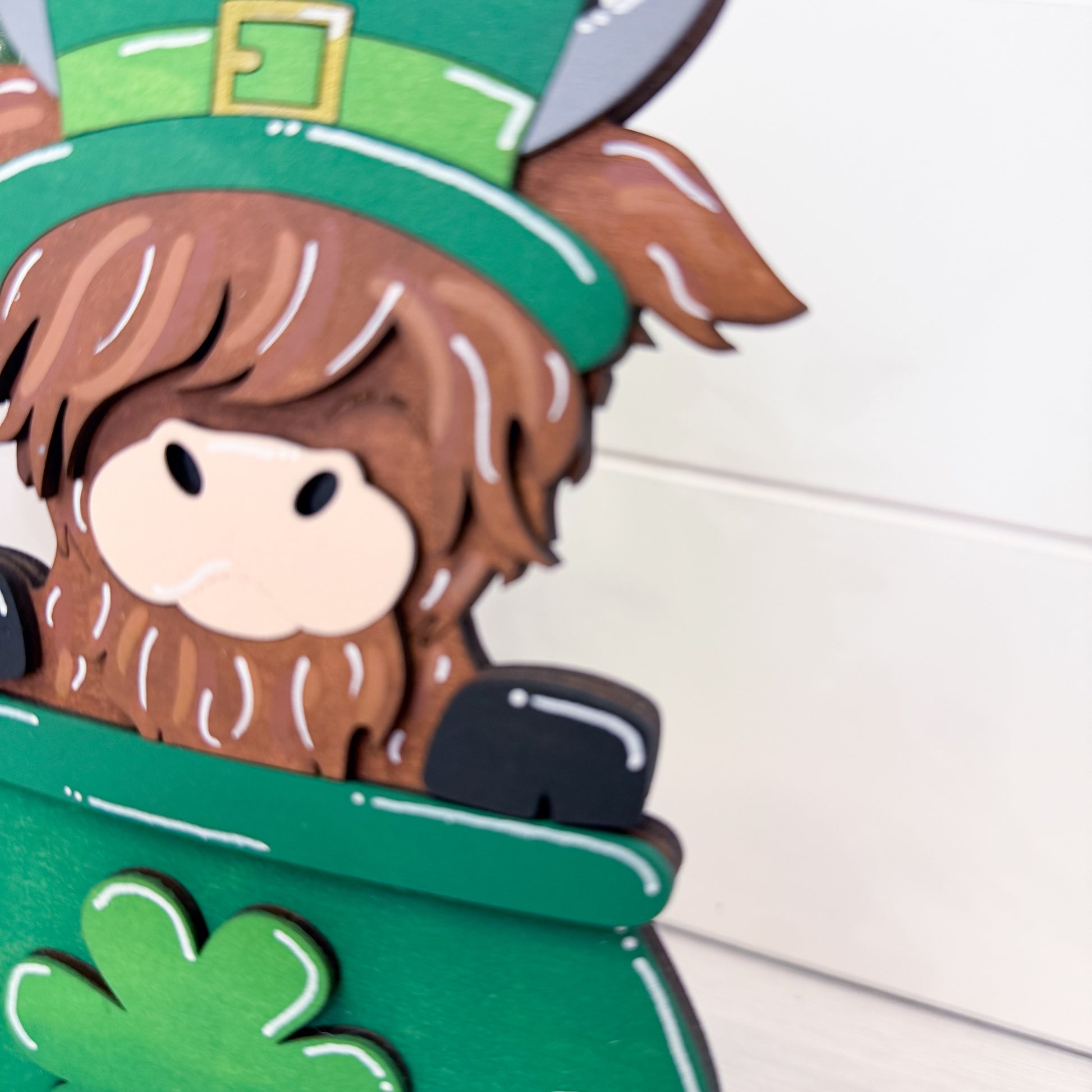 cow wearing a leprechaun hat with a pot of gold on a white background