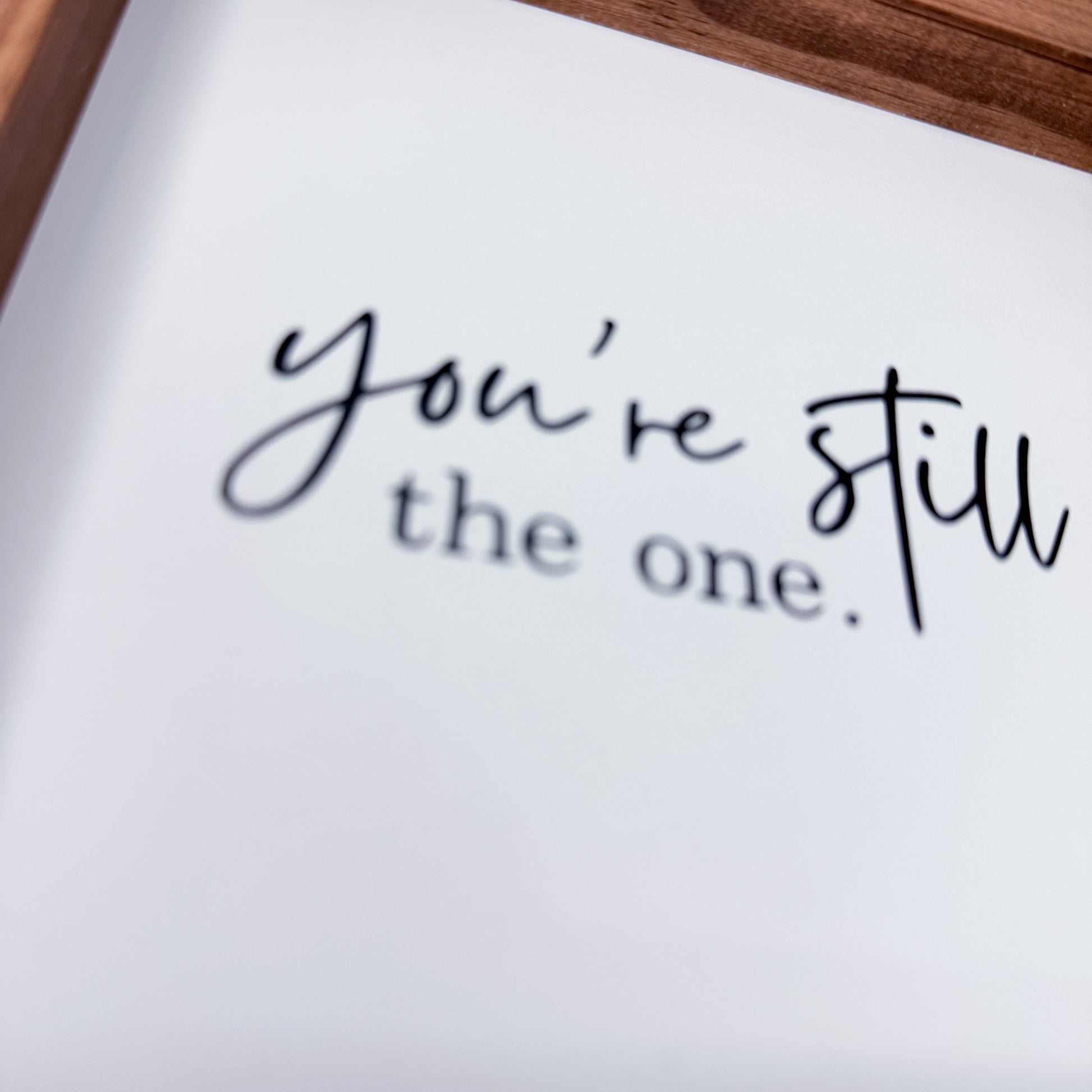 Note with 'you're still the one' text in a wooden frame