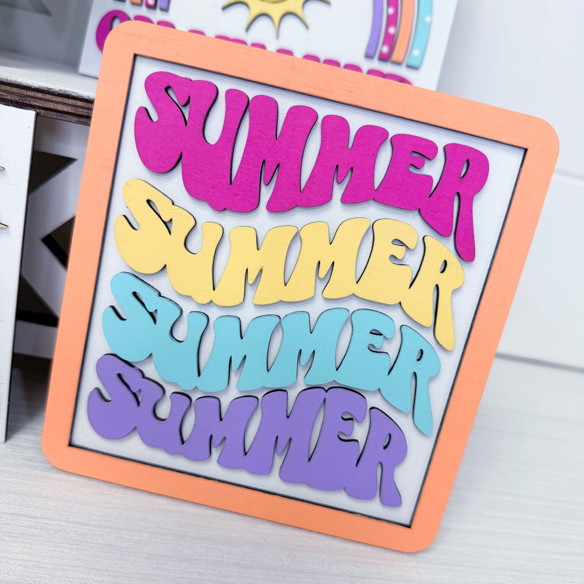 Colorful 'Summer' sign with an orange border on a light background