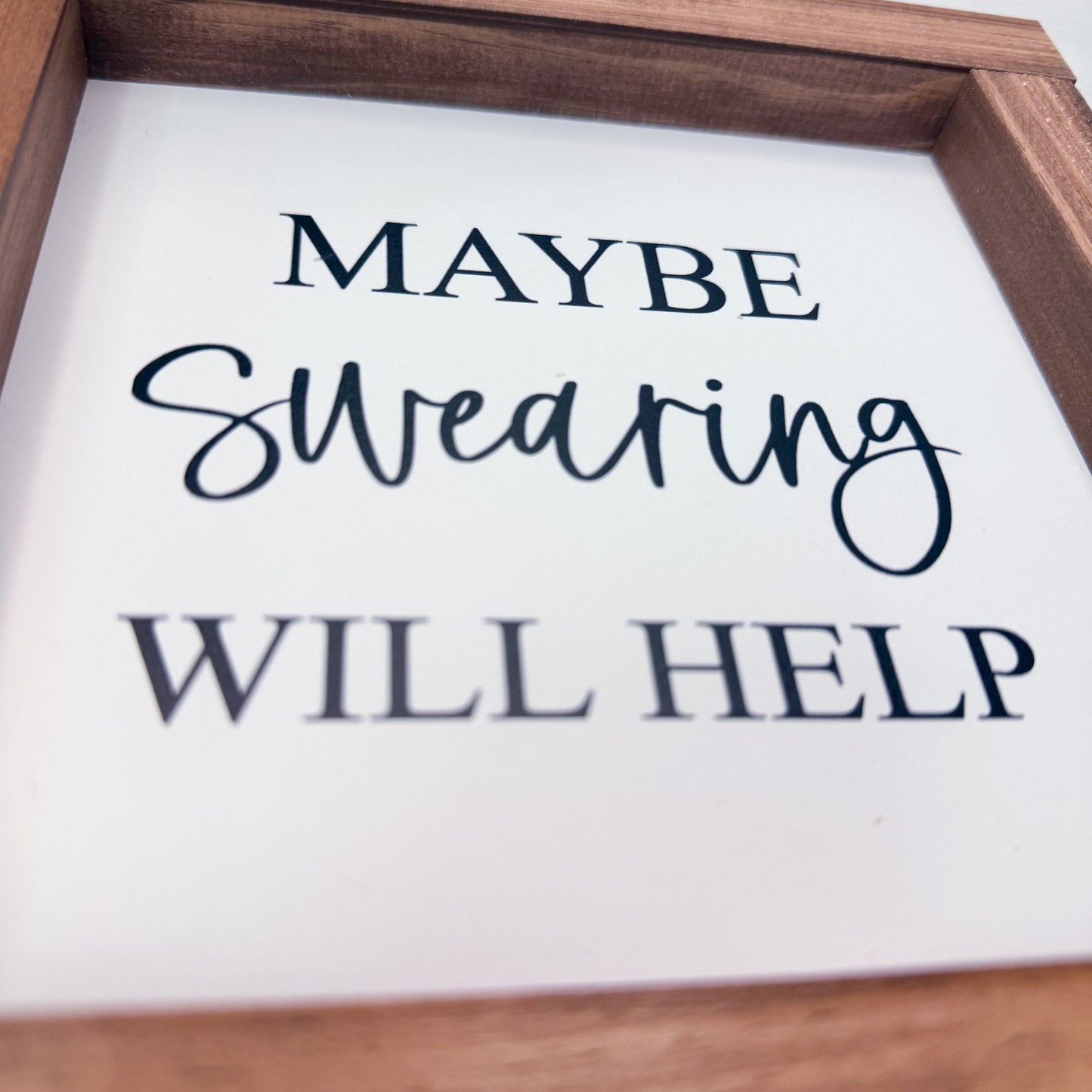 Wooden framed sign with text 'MAYBE Swearing WILL HELP' on a white background