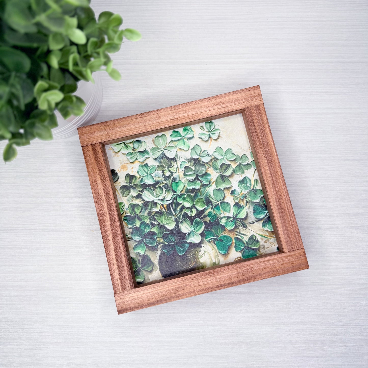 Framed artwork with green leaf pattern on a white background