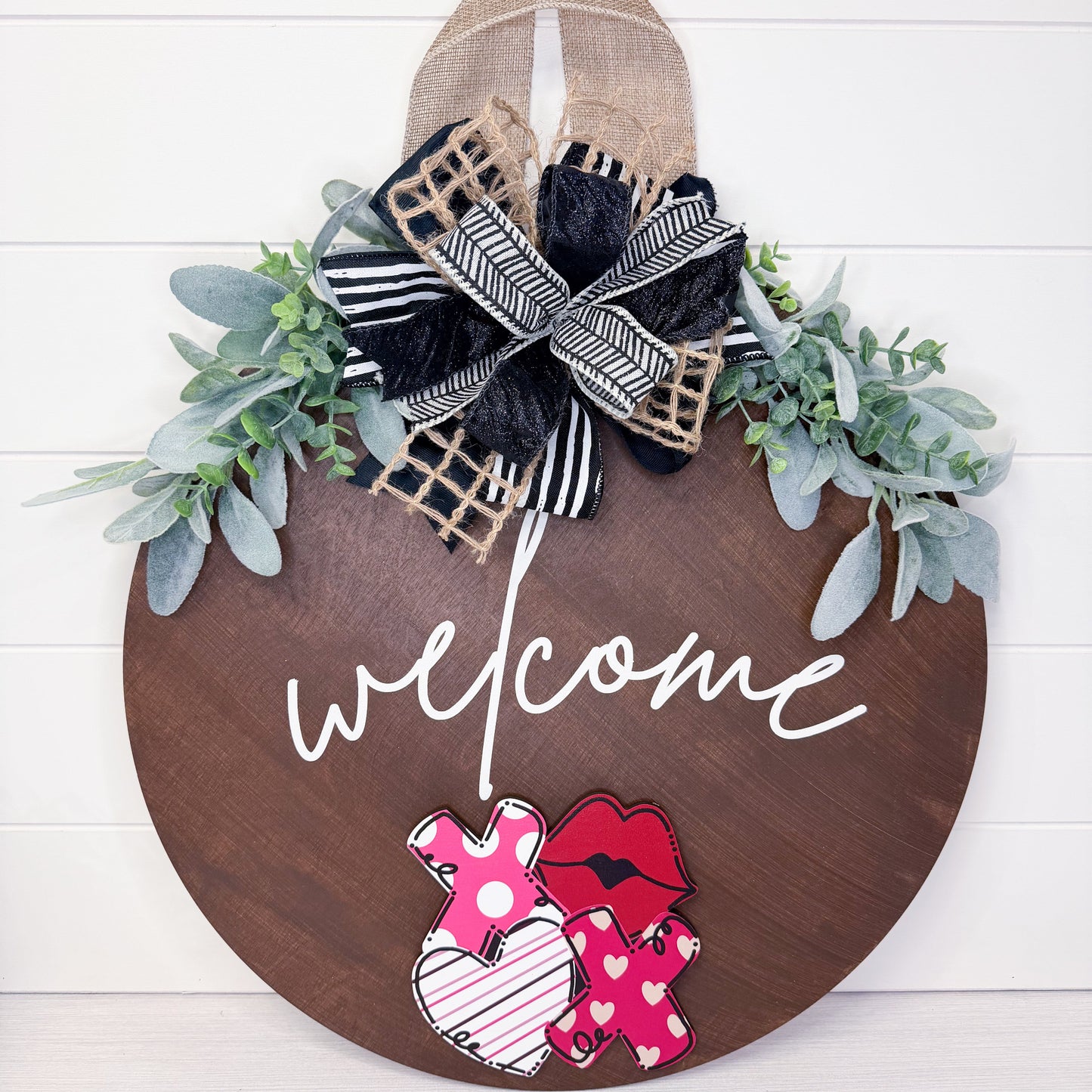 Wooden door hanger with 'welcome' text, floral decorations, and pajama-themed cutouts on a white background.