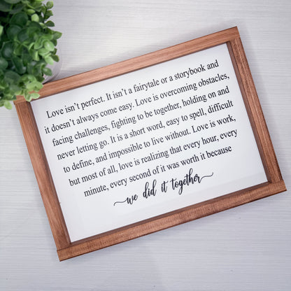 Wooden-framed sign with a romantic quote on a light background
