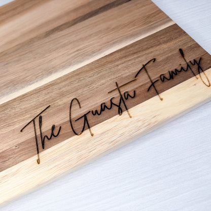 Wooden cutting board with 'The Guasta Family' engraving on a light background