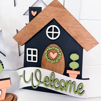Decorative house-shaped sign with 'Welcome' text on a white background