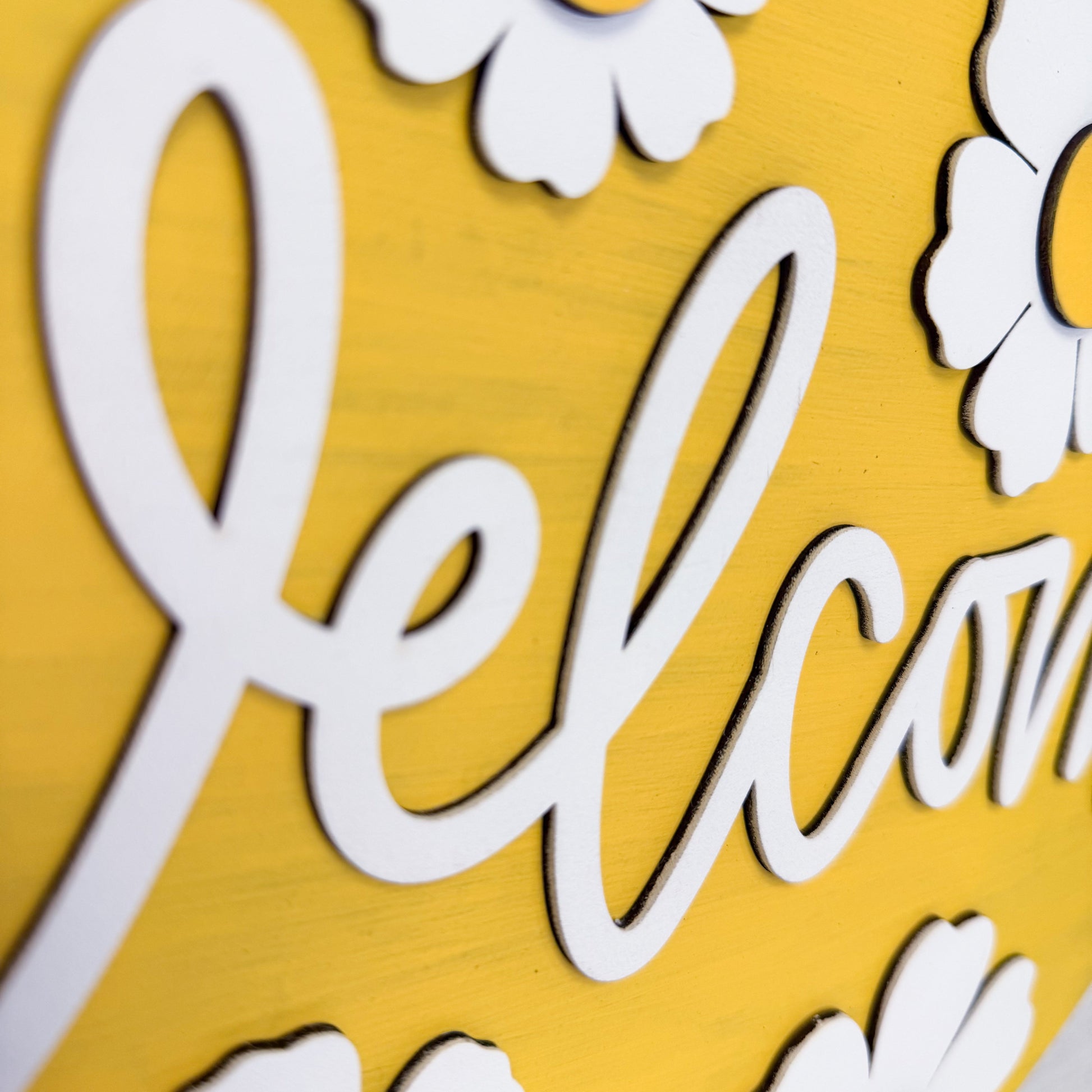 White 'Welcome' text on a yellow background with floral decorations